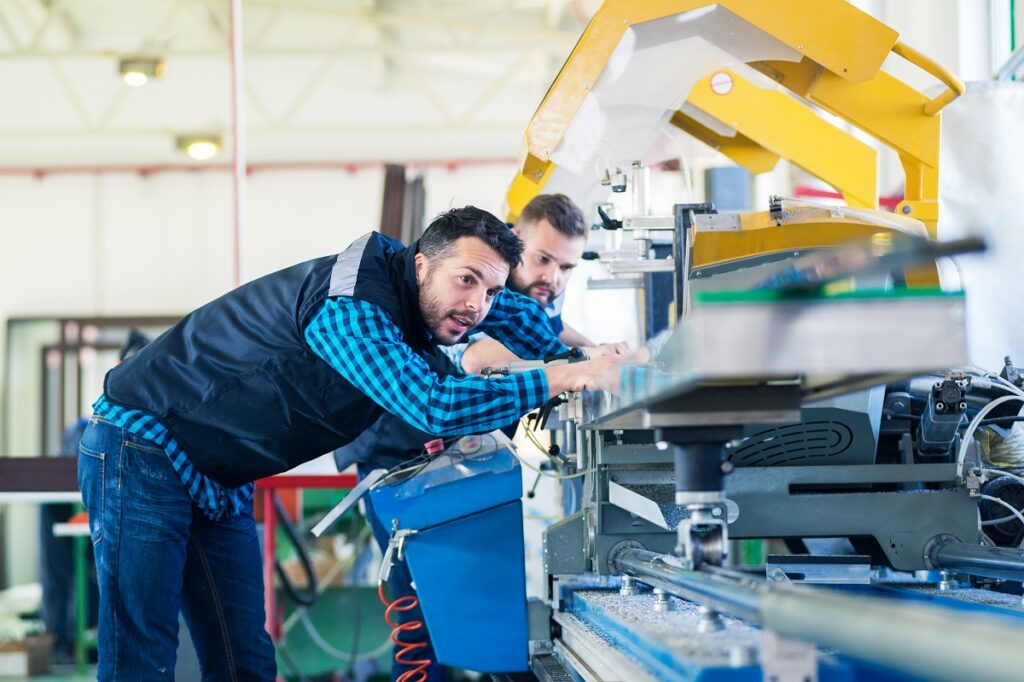 workers checking manufacturing machine